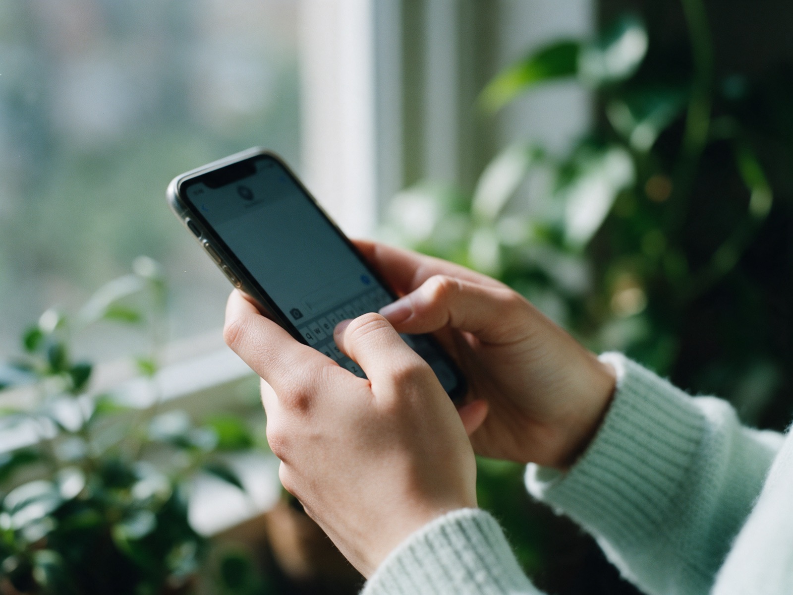 Mãos digitando uma mensagem no celular